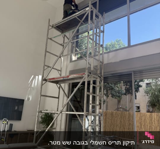 תיקון תריס גלילה חשמלי בגובה באמצעות פיגום בסלון